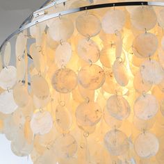 a chandelier made out of glass discs hanging from a ceiling fixture in a room