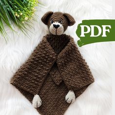 a crocheted teddy bear wearing a brown coat