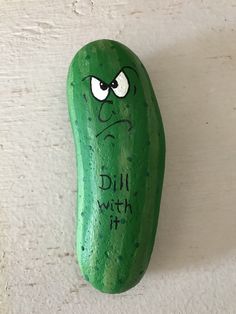 a green pickle with the words dill with me painted on it's face