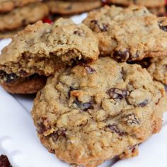 chocolate chip cookies stacked on top of each other with cranberries in the background