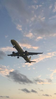 an airplane is flying in the sky at sunset