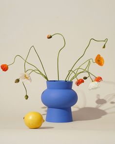 a blue vase filled with flowers next to an orange