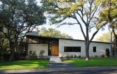 the house is surrounded by trees and grass