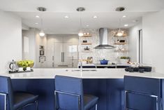 a kitchen with blue chairs and an island