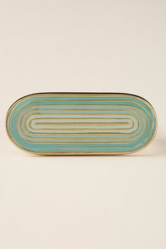 a blue and gold plate sitting on top of a white table