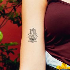 a woman's arm with a tattoo on it that has a lotus flower in the middle