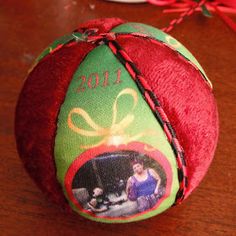 a christmas ornament on a table with a red ribbon around it and a green ball