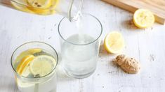 pitcher pouring water into two glasses filled with lemons