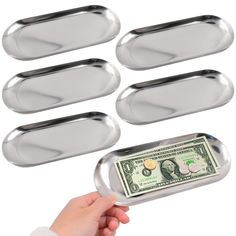 six metal trays with one dollar bill sticking out of the bottom, and five empty ones on each side