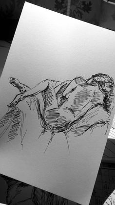 a drawing of a person laying down on the ground next to a piece of paper