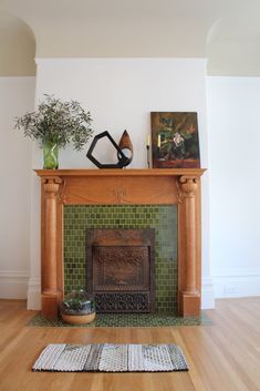 a living room with a fire place and rugs on the wooden floor next to it