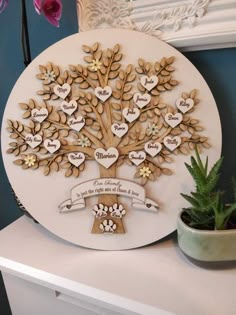 a family tree is shown with hearts and names on the wall next to a potted plant