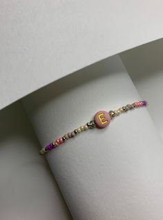 This cute coloristic bracelet is made in pinky shades, out of 2mm seed beads and 6 mm acrylic letter bead which can be personalised :)  The design of the lock makes it stand out and gives an interesting look to this minimalist bracelet.  Inspired by traditional Uzbek fabric pattern. ADJUSTABLE Length: 16.5 cm - 22.5 cm All iteams are uniquely design and made by me.  DISPATCHING AND DELIVERY  - It would require up to three working days for items to be made and dispatched. Shipping with a Tracking Embroidery Bracelet Initials, Personalized Pink Dainty Beaded Bracelets, Minimalist Handmade Name Bracelet For Everyday, Trendy Everyday Name Bracelet With Letter Beads, Trendy Letter Beads Friendship Bracelets As Gift, Trendy Letter Beads Friendship Bracelet As Gift, Trendy Friendship Bracelets With Letter Beads As Gift, Personalized Pink Bracelets For Everyday, Dainty Friendship Beaded Bracelets With Letter Beads