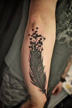 a man's arm with a black and grey feather tattoo on the left forearm