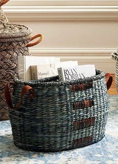 two baskets with books in them sitting on a rug