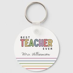 a round keychain with the words best teacher ever and rainbow stripes on it