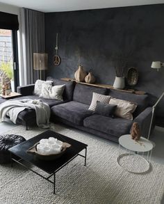 a living room filled with lots of furniture next to a large window and a rug on the floor