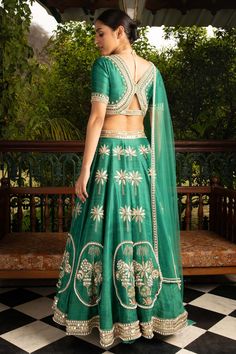 Editor's Note Green Lehenga Set In Raw Silk With Patchwork And Hand Embroidery In Raw Silk Patchwork. The Blouse Has A Flattering Neckline, Elbow Sleeves It Is Adorned With Statement Hand Embroidery. The Lehenga Skirt Has 14 Kalis And Is Adorned With Placement Patchwork And Hand Embroidery In Metallic Gold And Pearl. This Comes With Matching Sheer Net Dupatta With A Statement Hand Embroidered Border In Metallic Gold And Pearl Color: Green Fabric: Raw Silk, Net Care: Dry Clean Only About the Desi Luxury Silk Lehenga With Cutdana, Luxury Silk Lehenga With Cutdana Detailing, Luxury Handloom Dola Silk Lehenga, Cheap Art Silk Designed Lehenga, Luxury Dola Silk Lehenga For Celebrations, Luxury Slub Silk Lehenga For Diwali, Luxury Art Silk Lehenga For Traditional Ceremonies, Luxury Silk Blouse With Cutdana, Luxury Silk Thread Lehenga For Party