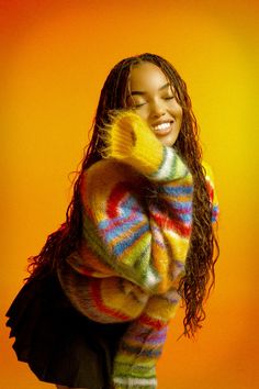 a woman with long hair wearing a colorful sweater