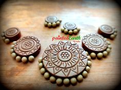 several decorated cookies sitting on top of a wooden table next to some beads and buttons