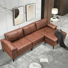 a brown leather sectional sofa sitting on top of a carpeted floor next to a lamp