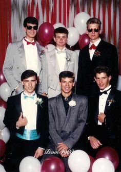 a group of young men standing next to each other in front of balloons and streamers