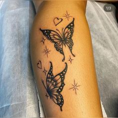 a woman's arm with two butterflies on it and hearts in the background,