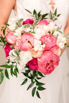 a bridal holding a bouquet of pink and white flowers