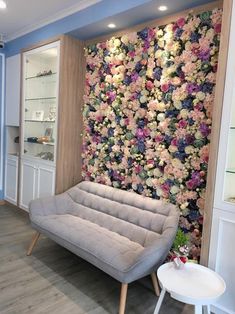 a living room with flowers on the wall and a couch in front of it,