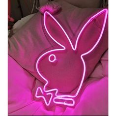 a neon pink bunny pillow on top of a bed