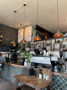 the interior of a coffee shop with hanging lights