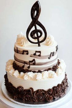 a three tiered cake with music notes on top and chocolate icing around the edges