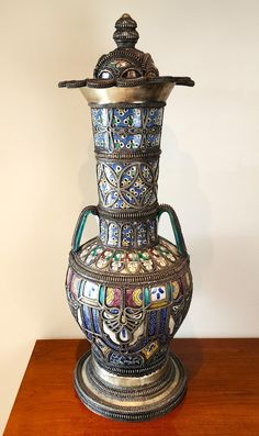 an ornate vase sitting on top of a wooden table