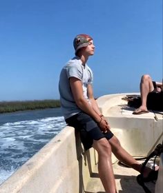 two people are sitting on the edge of a boat in the water and one person is wearing flip flops