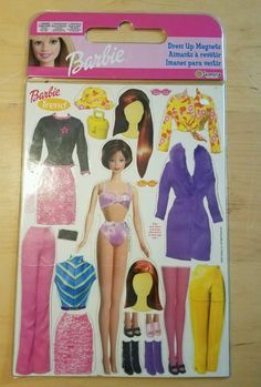 the barbie doll is in its package on the wooden table with it's clothes