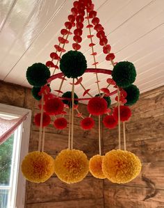 three pom poms hanging from a chandelier in a room with wood paneling