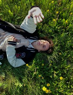 a woman laying in the grass with her arms outstretched