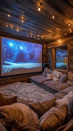 a large screen in the corner of a room with lots of pillows and blankets on it