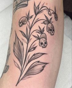 a tattoo with skulls and leaves on it