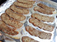 several hamburger patties are sitting on top of tin foil and ready to be cooked