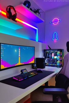 a computer desk with two monitors and a keyboard in front of the monitor is lit up by neon lights