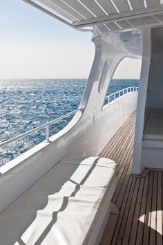 the back deck of a boat with sunbathers and water in the background royalty photo