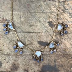 When raindrops fall from a cloud, we must always see the silver lining. Aquamarine and blue sapphires are embedded in brass and dangle from our signature brass chain with a handmade clasp. Pendant Length 1" Pendant Width 3/4" Necklace Length 20" - 22" This piece is handmade-to-order, please allow 1 - 2 weeks to ship unless this piece is in stock. Each piece will vary slightly due to the uniqueness of the stones. All metal is nickel free. Brass Teardrop Pendant For Jewelry Making, Blue Brass Jewelry With Adjustable Chain, Unique Blue Long Drop Jewelry, Adjustable Teardrop Brass Necklace, Unique Brass Teardrop Necklaces, Unique Teardrop Necklace With Lobster Clasp, One Of A Kind Brass Dangle Jewelry, Unique Blue Drop Jewelry, Artisan Drop Gemstone Jewelry