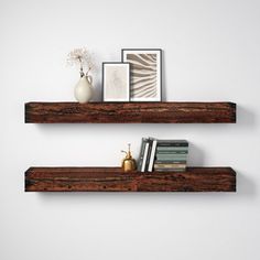 two wooden shelves with books and vases on each shelf, against a white wall