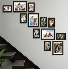 a stair case with many pictures hanging on the wall next to it and a potted plant