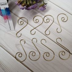 gold metal wire numbers are sitting on a table next to purple flowers and a card