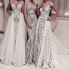 three beautiful women standing next to each other in front of a mirror wearing gowns