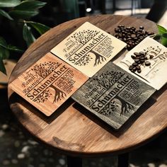 three wooden coasters sitting on top of a table next to coffee beans and plants