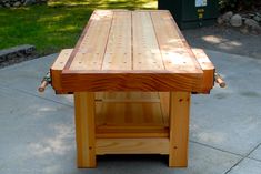 a wooden table sitting on top of a sidewalk