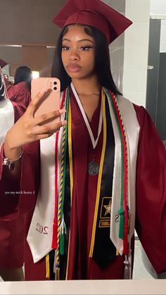 a woman in graduation gown taking a selfie with her cell phone